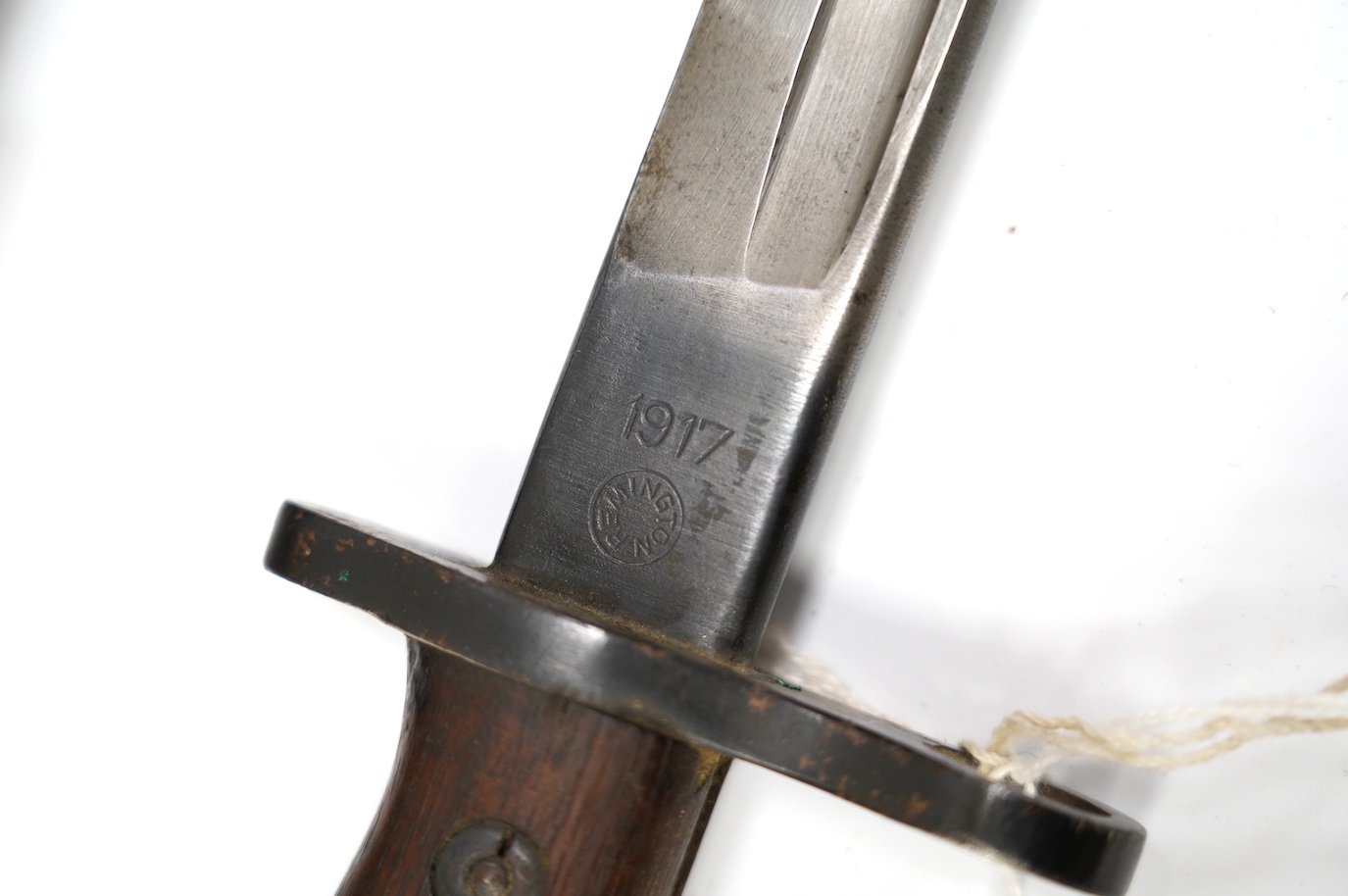 An American 1917 Remington bayonet, based on the earlier British bayonet of 1913, adapted for the 0.3 to 0.6 calibre rifles, with its leather covered scabbard. Condition - good